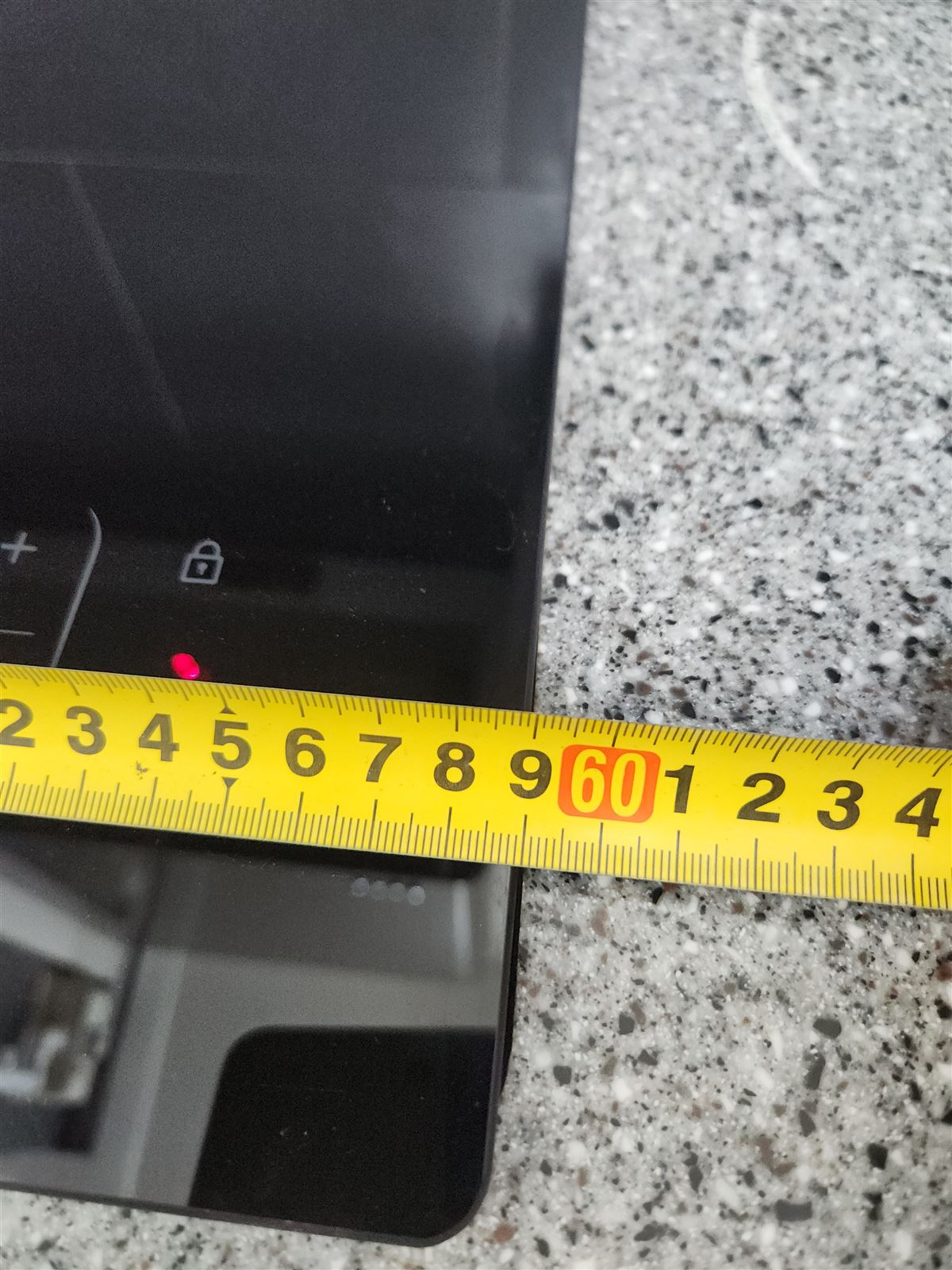새 전기레인지 크기를 줄자로 재는 모습